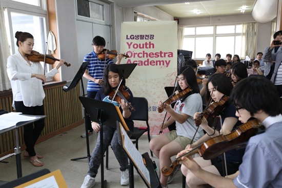 ▲‘LG생활건강 유스오케스트라 아카데미(Youth Orchestra Academy) 멘토스쿨’에서 세계적인 바이올린 연주자 강주미씨가 LG생활건강 유스오케스트라 아카데미 단원들과 함께 협연을 하고 있는 모습