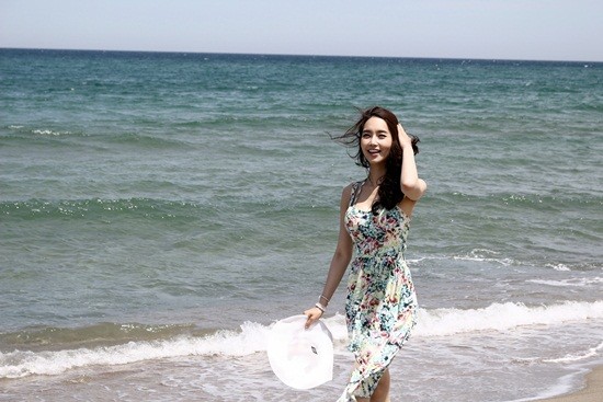 환한 미소를 띄며 바닷가를 걷는 김유미